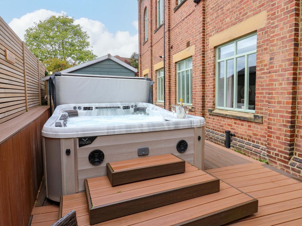 A hot tub with steps on wood decking at The Miners Hall Retreat, Stanley, County Durham