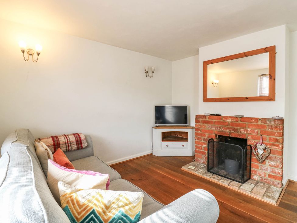 A living room with a sofa, television, and fireplace at 5 Prospect Place in Woodbridge
