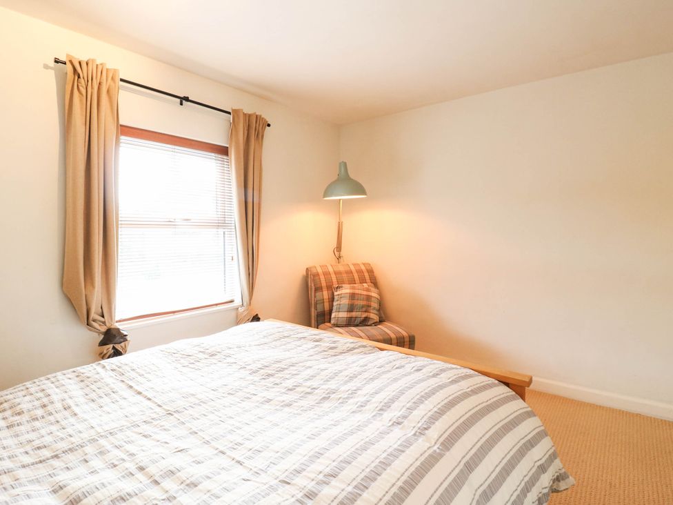 A bedroom with a bed and a chair at 5 Prospect Place in Woodbridge
