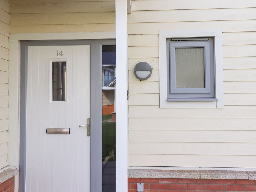 A front door with a mail slot and a small window at The Beach House (Beadnell) Beadnell