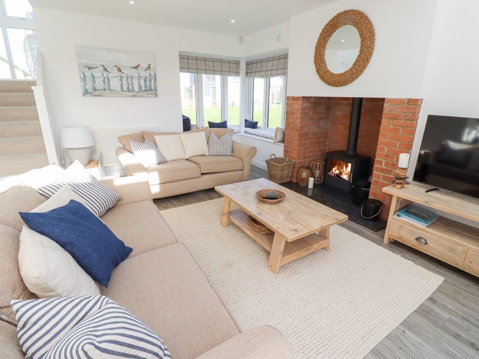 A living room with a sofa, coffee table, and fireplace at The Beach House (Beadnell)