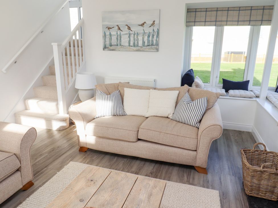 A living room with a sofa and cushions at The Beach House in Beadnell