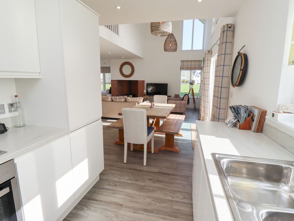 A kitchen with a dining table and sofa at The Beach House in Beadnell