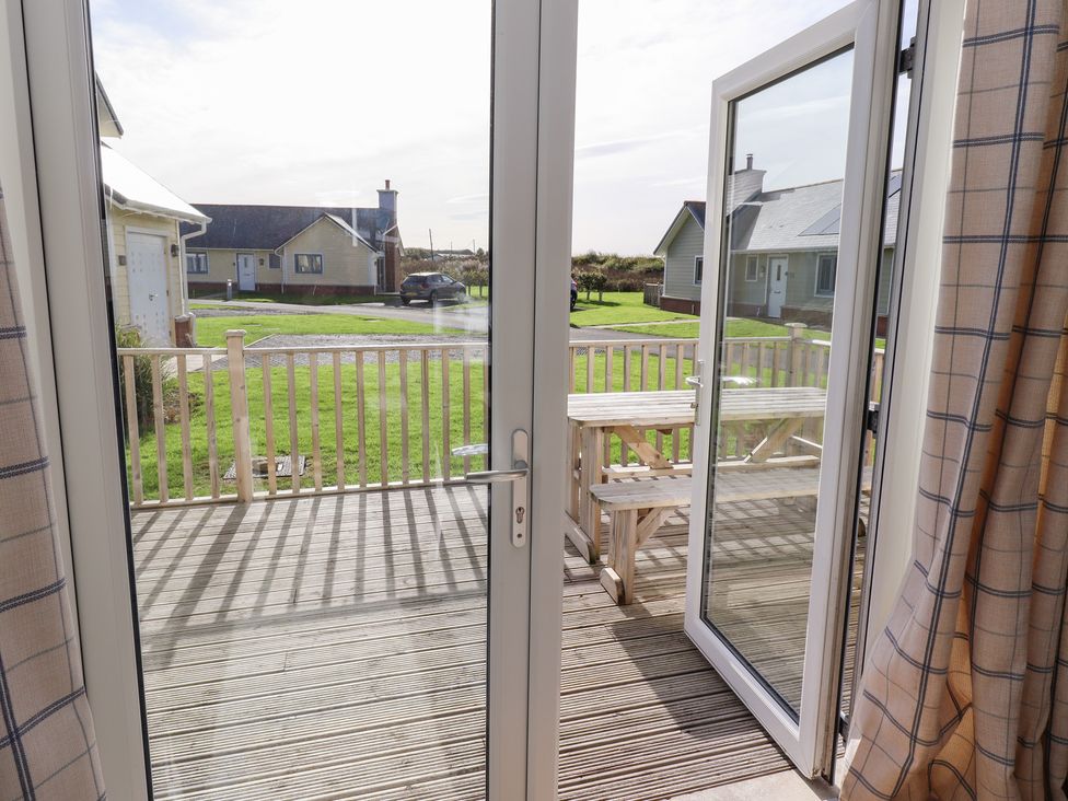 A view from inside through an open door onto a deck at The Beach House in Beadnell