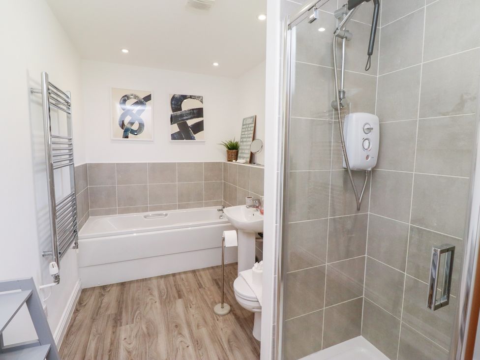 A bathroom with a bathtub and shower at The Beach House (Beadnell)