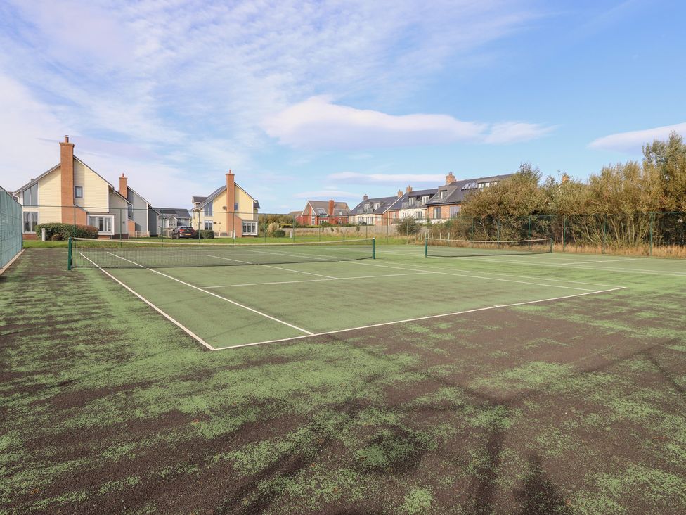 A tennis court with houses in the background at The Beach House (Beadnell) Beadnell