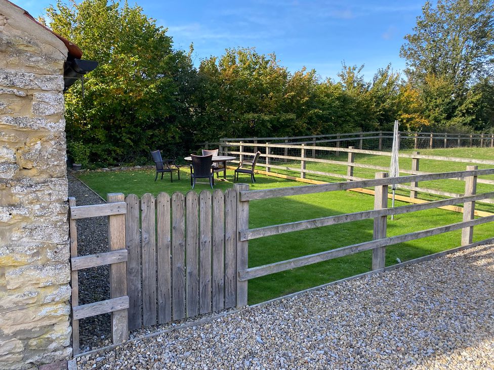 A garden with a gate and furniture at Puddleduck Cottage Thornton-Le-Dale
