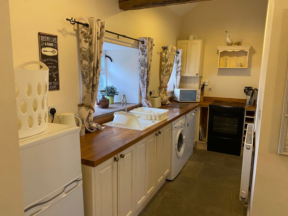 A kitchen with appliances and cabinets at Puddleduck Cottage Thornton-Le-Dale