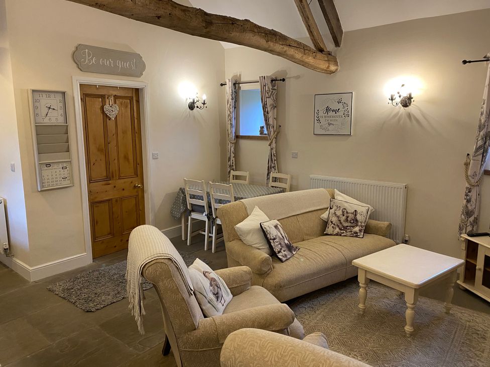 A living room with a sofa and dining table at Puddleduck Cottage in Thornton-Le-Dale