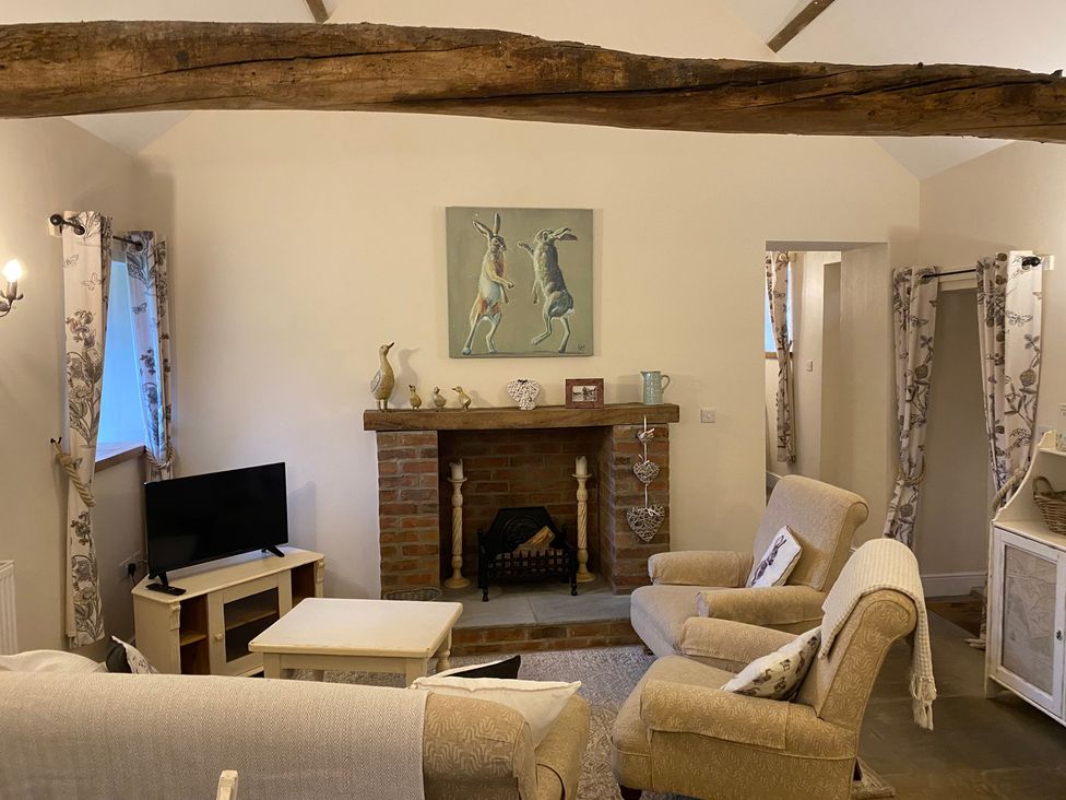 A living room with a sofa and television at Puddleduck Cottage in Thornton-Le-Dale