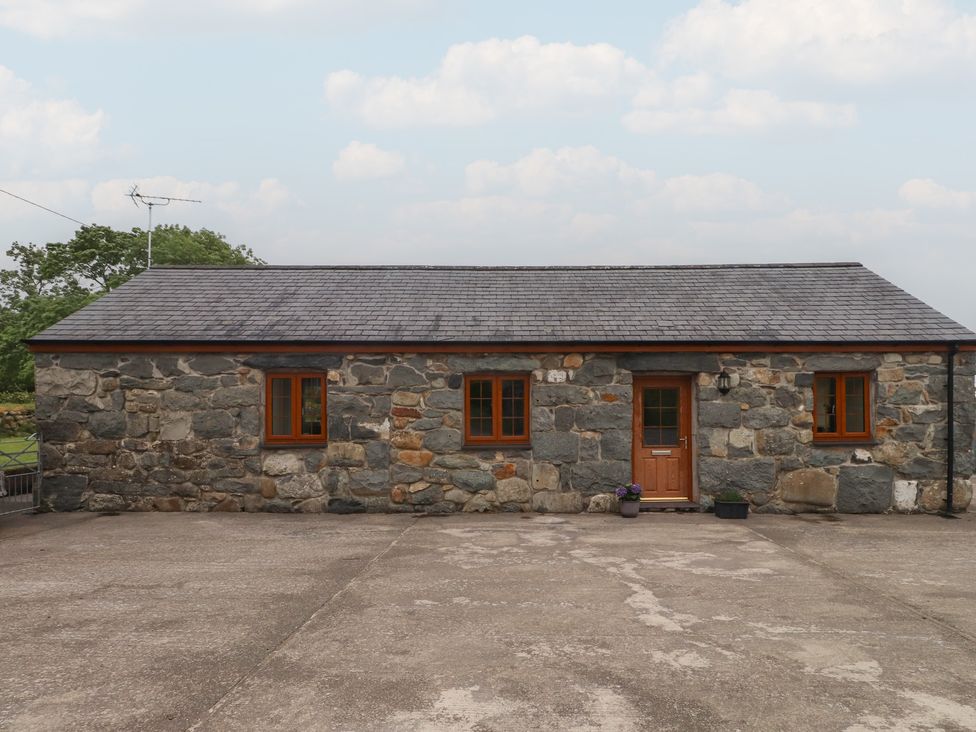 A stone cottage with windows and a door at Bryn Caled in Llanarmon near Y Ffor