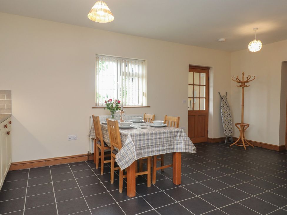 A kitchen with a dining table and chairs at Bryn Caled in Llanarmon near Y Ffor