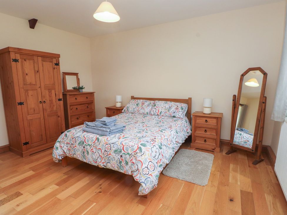 A bedroom with a bed and wardrobe at Bryn Caled in Llanarmon near Y Ffor