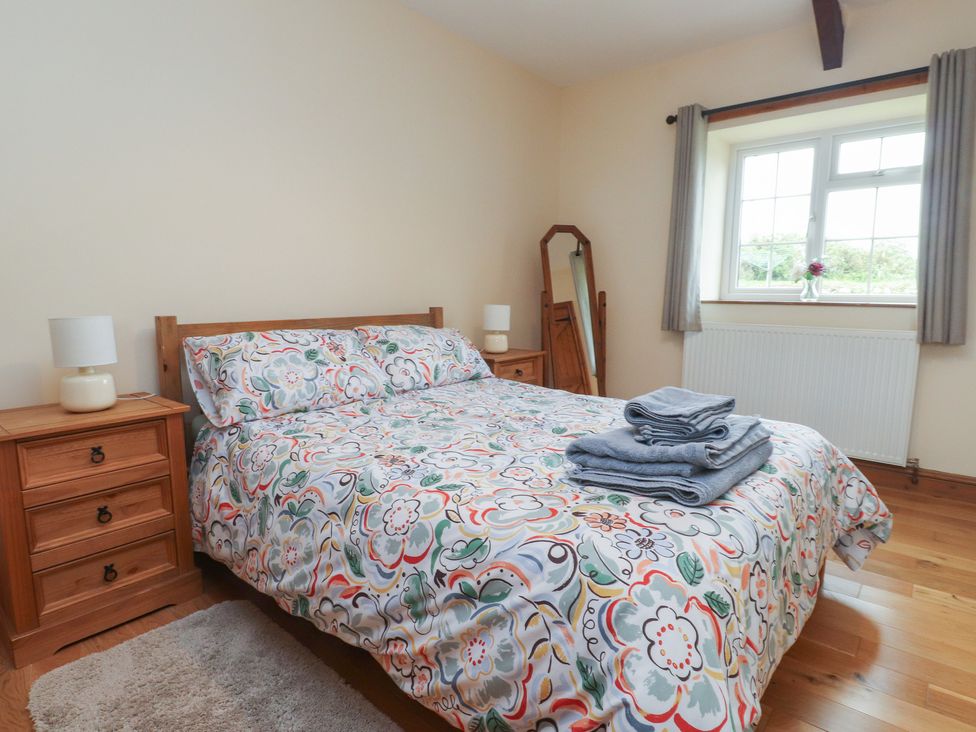 A bedroom with a bed and bedside tables at Bryn Caled in Llanarmon near Y Ffor