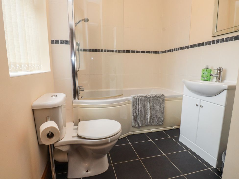 A bathroom with a bathtub and shower at Bryn Caled in Llanarmon near Y Ffor