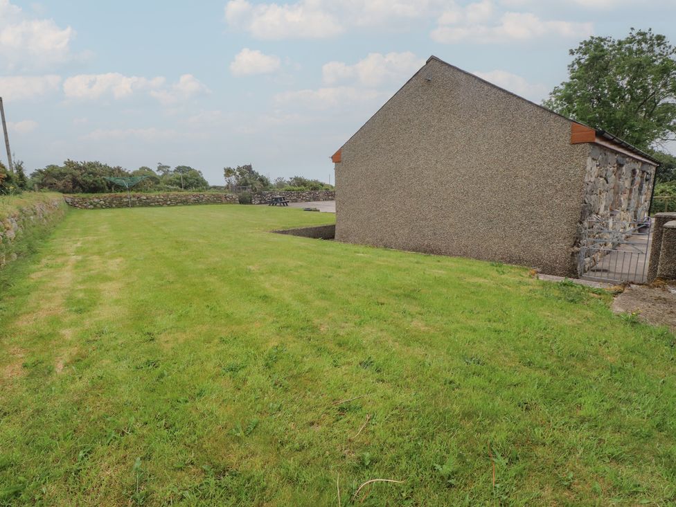 A garden area with grass and a building at Bryn Caled in Llanarmon near Y Ffor
