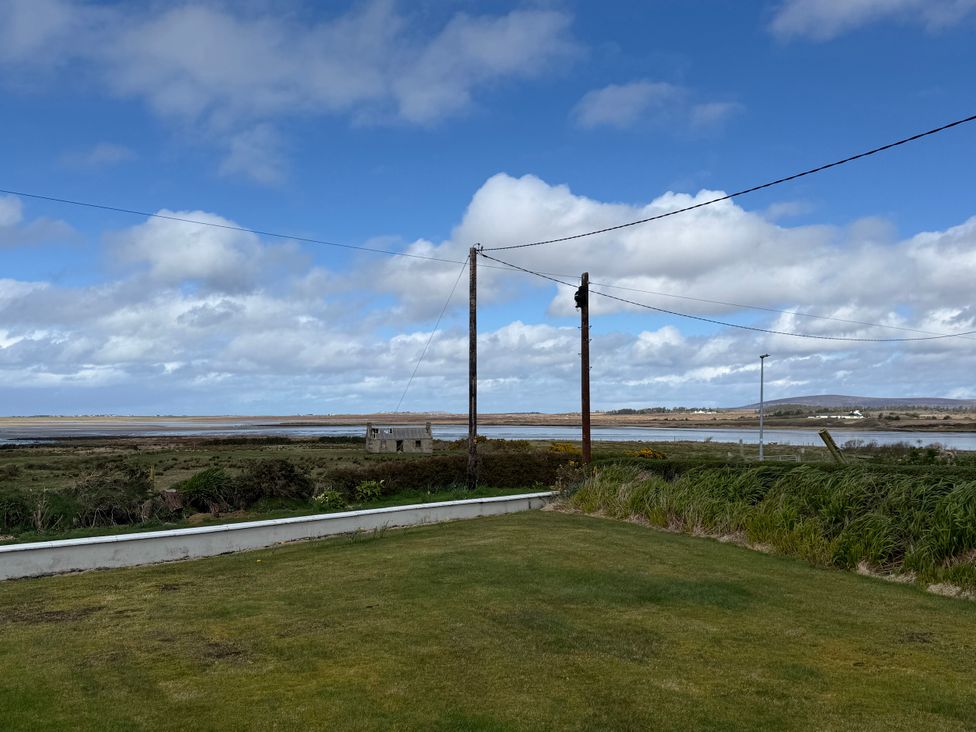A view of grass and water with power lines at Geesala