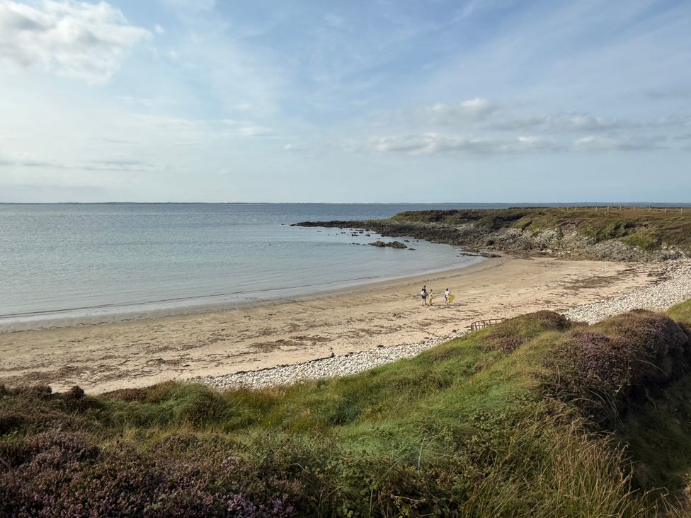 A beach scene with people walking along the shore at Geesala