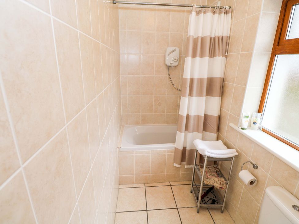 A bathroom with a bathtub, shower, and toilet at Geesala, Gweesalia