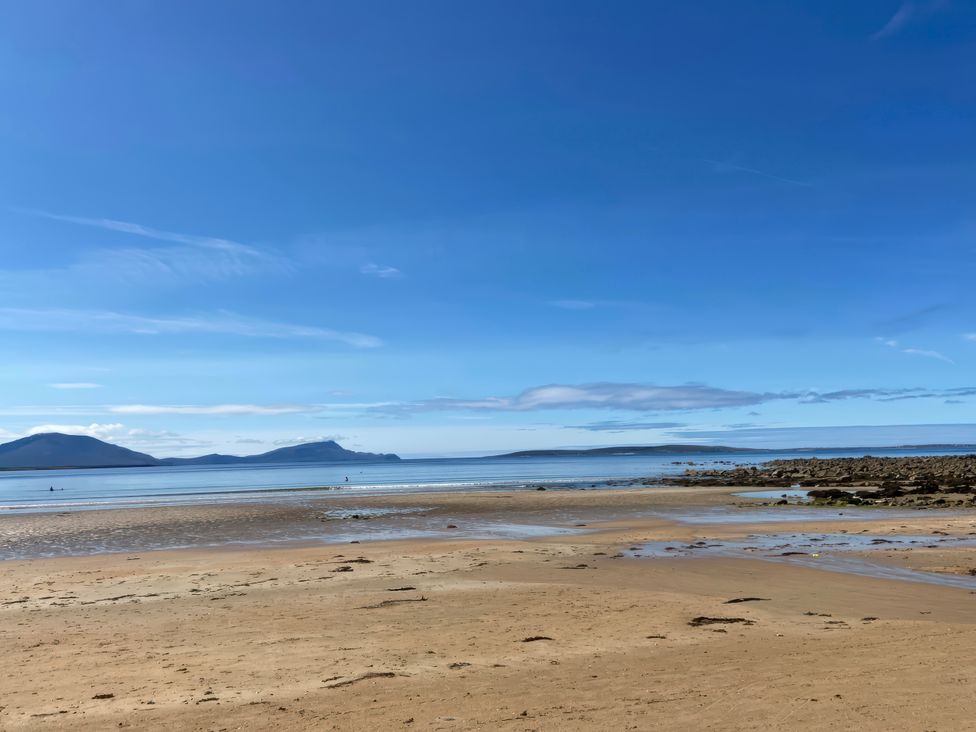 A beach with sand and sea under a clear sky at Geesala in Gweesalia