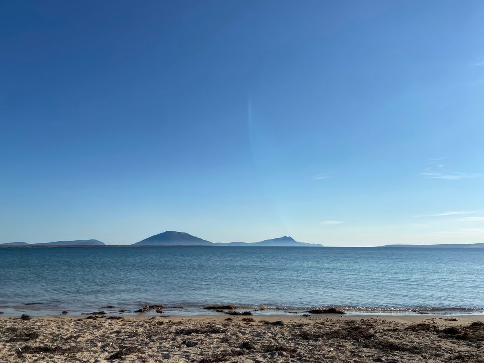 A beach view with mountains in the distance at Geesala in Gweesalia