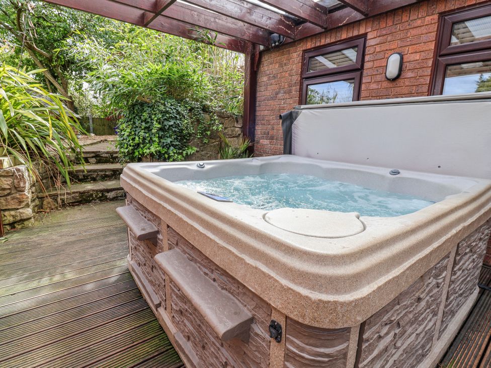 A hot tub with steps and plants at Acorns in Holywell