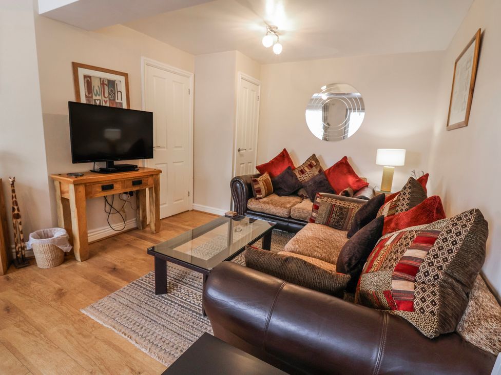 A living room with a sofa and television at Acorns in Holywell
