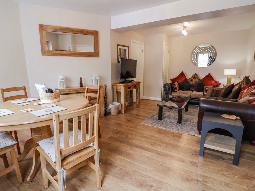 A living room with a dining area and television at Acorns in Holywell
