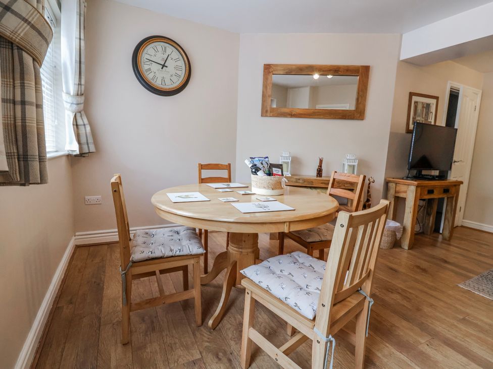 A dining room with a table and chairs at Acorns in Holywell