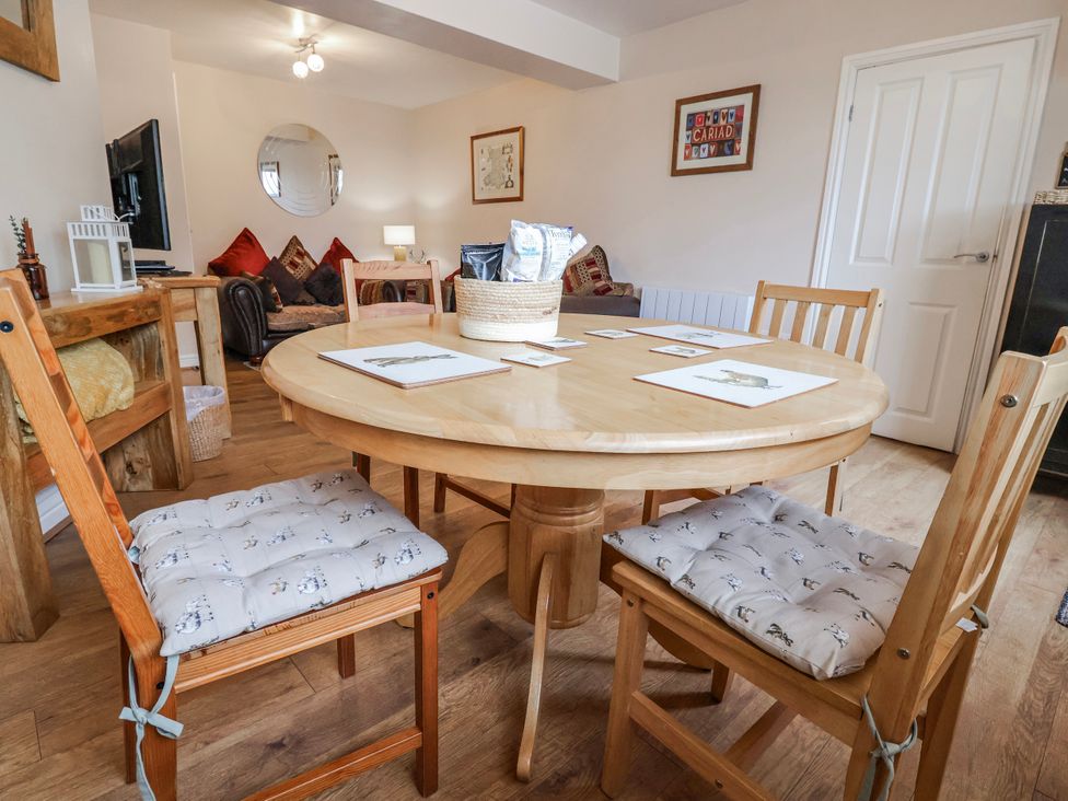 A dining room with a round table and chairs at Acorns in Holywell