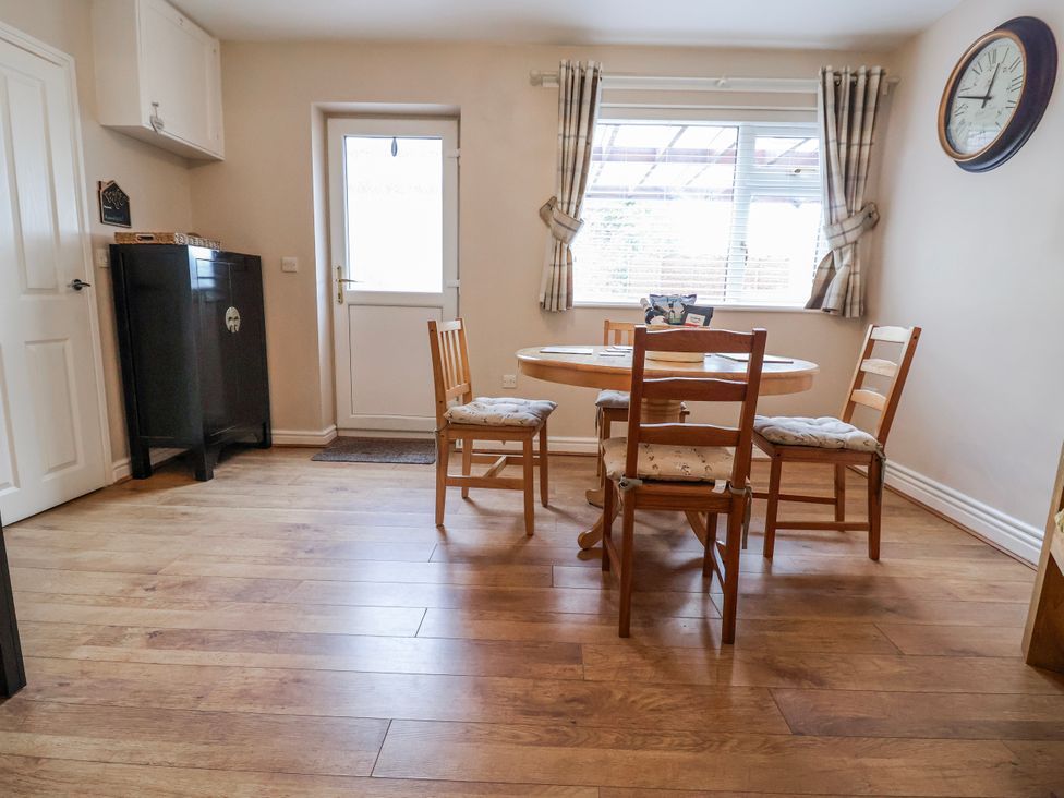 A dining room with a table and chairs at Acorns in Holywell