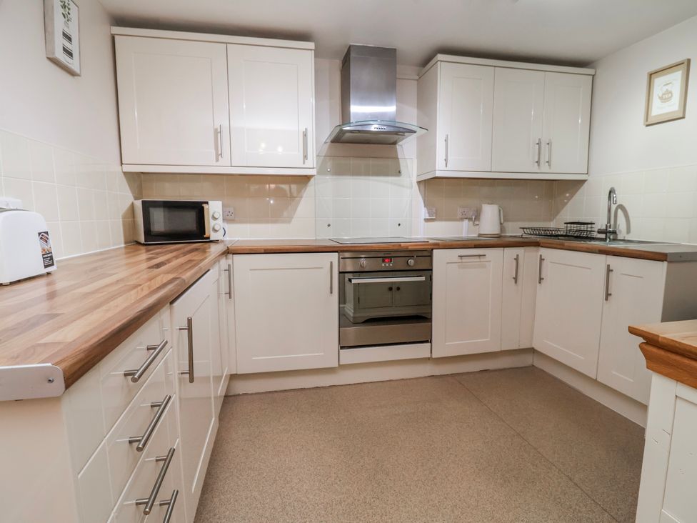 A kitchen with appliances and cabinets at Acorns in Holywell