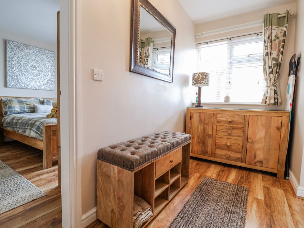 A hallway with a bench and a mirror at Acorns in Holywell