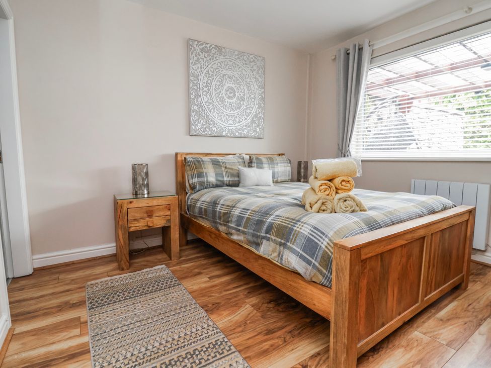 A bedroom with a bed and bedside table at Acorns in Holywell
