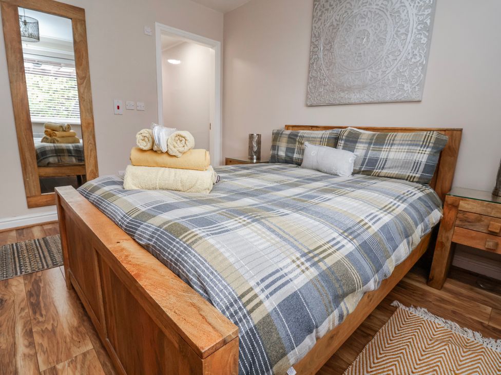 A bedroom with a bed and towels on top at Acorns in Holywell
