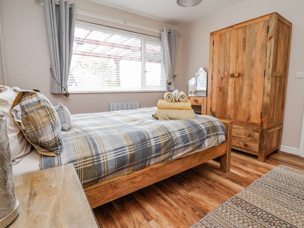 A bedroom with a bed and wardrobe at Acorns in Holywell