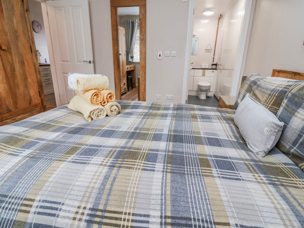 A bedroom with a bed and towels arranged at Acorns in Holywell