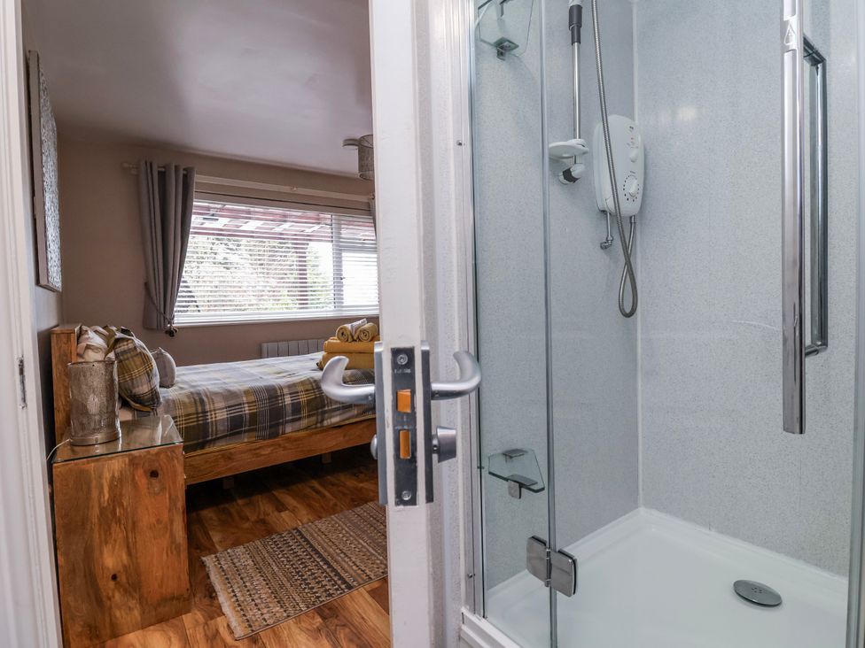 A shower and a bed in a bedroom with an ensuite at Acorns in Holywell