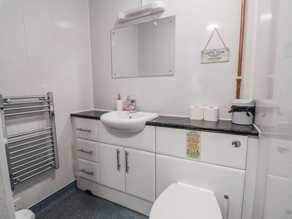 A bathroom with a sink and storage cabinet at Acorns in Holywell