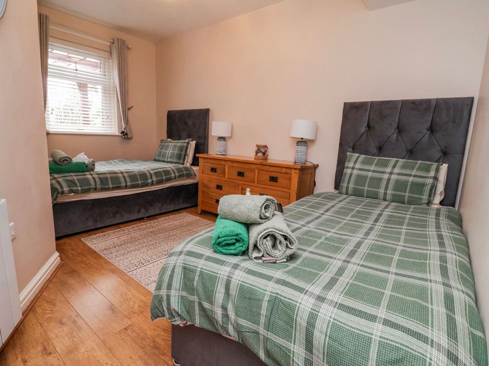 A bedroom with two single beds and a dresser at Acorns in Holywell