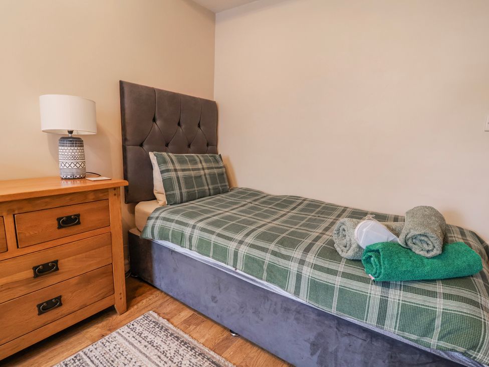 A bedroom with a bed and a lamp at Acorns in Holywell