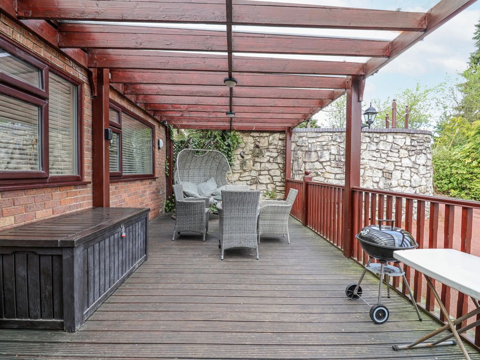 A deck with outdoor furniture and a grill at Acorns in Holywell