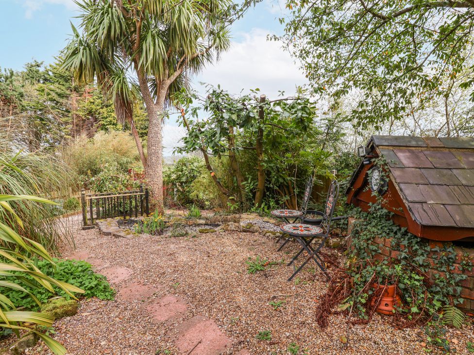 A garden area with a tree and seating at Acorns Holywell