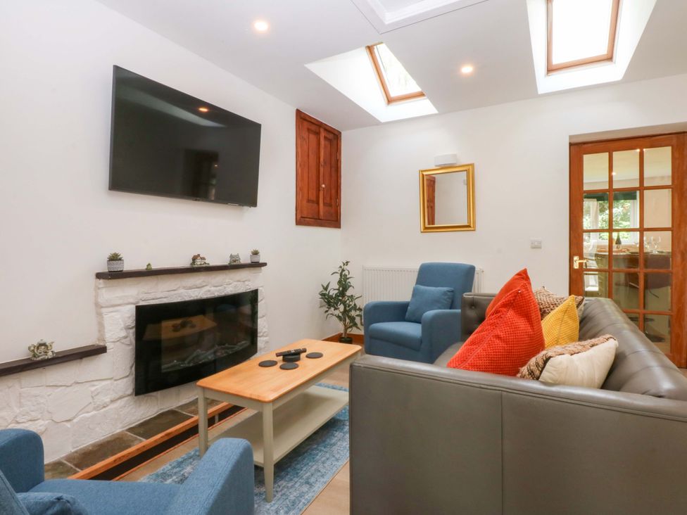 A living room with a fireplace and television at Cromlech Cottage at Cromlech Manor Farm near Tyn-y-Gongl