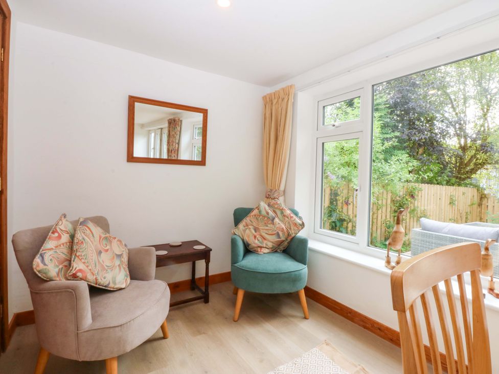 A snug area with two armchairs and a side table at Cromlech Cottage at Cromlech Manor Farm Tyn-y-Gongl near Benllech