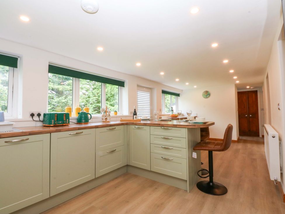 A kitchen with a countertop and windows at Cromlech Cottage at Cromlech Manor Farm near Tyn-y-Gongl