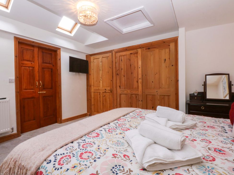 A bedroom with a bed and towels on it at Cromlech Cottage at Cromlech Manor Farm in Tyn-y-Gongl near Benllech
