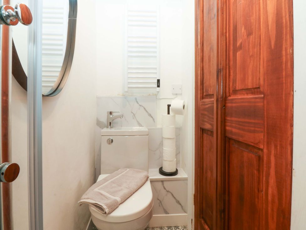 A bathroom with a toilet and towel at Cromlech Cottage at Cromlech Manor Farm, Tyn-y-Gongl near Benllech