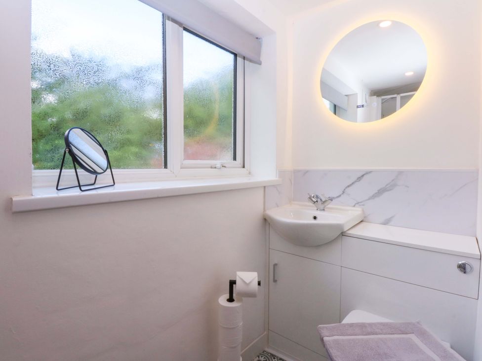 A bathroom with a sink and mirror at Cromlech Cottage at Cromlech Manor Farm Tyn-y-Gongl near Benllech