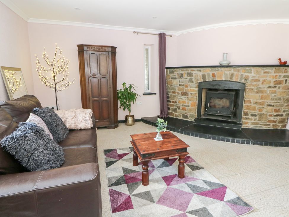 A living room with a sofa and coffee table at Garden apartment in Llandysul